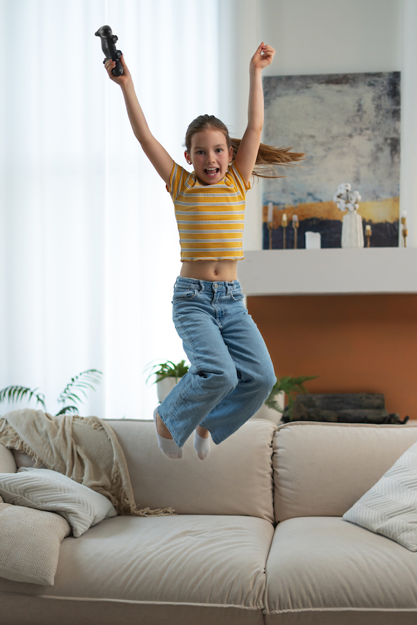 Девочка прыгает на диване